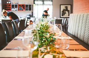 The dining room, dressed with greenery and set for service.